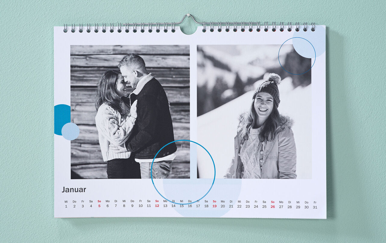 Pe peretele verde-mentă atârnă un calendar decorat cu fotografii de iarnă alb-negru și alb-negru și cliparturi circulare albastre.